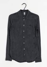 Camicia in denim nera a maniche lunghe con colletto classico, taschino frontale e chiusura a bottoni a pressione. Caratterizzata da un tessuto texturizzato e un orlo arrotondato.
