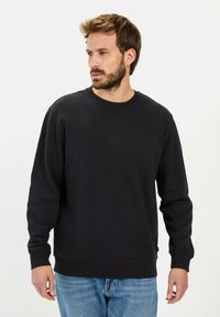 Zwarte sweatshirt van zachte stof met een ronde hals, lange mouwen en ribbelmanchetten. Heeft een subtiele logo op de linkermouw.