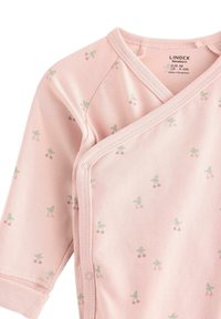 Vaaleanpunainen pitkähihainen body, jossa on kietaisusuunnittelu ja vihreä-pinkki kirsikkakuosi. Pehmeä kangas, jossa on neppari sivussa.