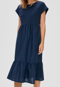 Marineblaues Baumwollkleid mit kurzen Ärmeln, lockerer Passform, gestuftem Rüschensaum und glatter Textur. Das Oberteil hat einen runden Ausschnitt.