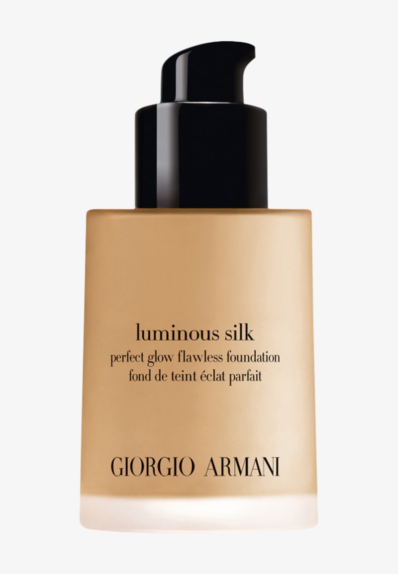 Glass fundamentflaske med en beige nyanse. Svart pumpehette og fet svart tekst som sier "luminous silk" og "Giorgio Armani" på forsiden.