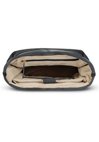 Avoin musta ja beigepohjainen pehmustettu kannettavan tietokoneen laukku, jossa on beigepinnoitettu vetoketjullinen tasku ja tarranauhalla varustettu hihna laitteiden turvallisuutta varten.