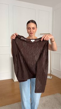 Maglione marrone, leggero, a coste con una vestibilità oversize, maniche lunghe e un ampio scollo, dotato di strisce verticali testurizzate.
