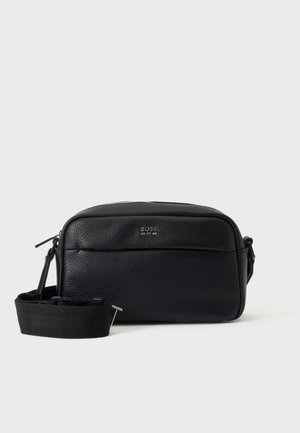 Čierna kožená kabelka crossbody s textúrou, predným vreckom, strieborným logom BOSS a nastaviteľným širokým popruhom na jednoduchom svetlom pozadí.