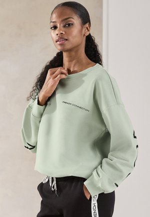 Mintgrüner Sweatshirt mit lockerer Passform, ausgestattet mit einem gerippten Ausschnitt und aufgedrucktem Logo. Schwarze Akzente an den Ärmeln sorgen für Kontrast.