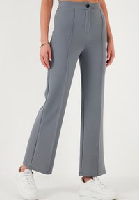 Gray wide-leg trousers made of textured fabric, featuring a button closure, front pockets, and a smooth waistband. Paired with white sneakers.