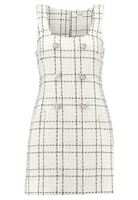 Vit texturerad klänning med svart rutmönster, fyrkantig halsringning och fyra dekorativa knappar framtill. Figursydd silhuett, utan ärmar.