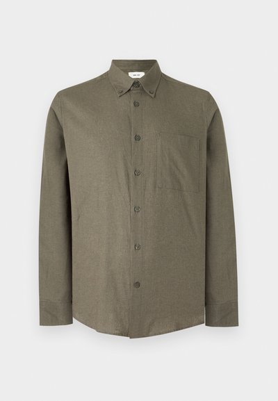 Chemise à manches longues vert olive boutonnée, avec col et poche poitrine, présentée de face sur un fond gris clair uni.