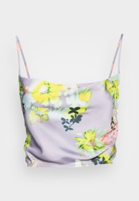 Camisole florale avec des bretelles fines, en tissu lavande clair orné de fleurs jaunes et roses vives, texture lisse et coupe décontractée.