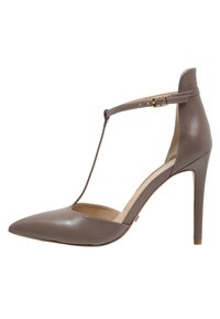 Chaussure à talon haut en cuir marron avec un bout pointu, un design à sangle en T et une boucle de cheville réglable. Texture lisse avec une silhouette fine et élégante.