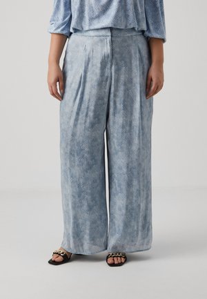Light blue wide-leg trousers with a textured pattern, pleated front, and soft fabric. Black sandals with gold chain accents.
