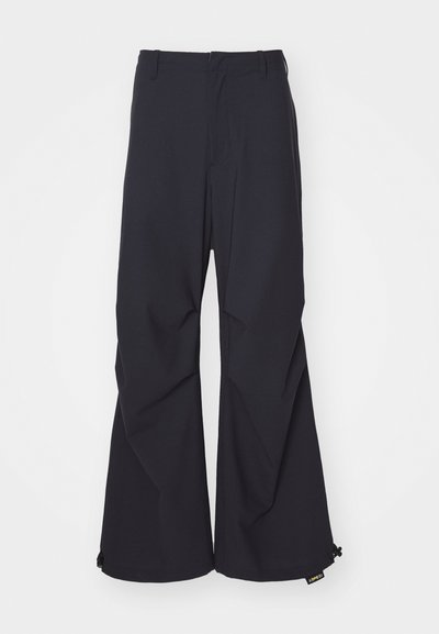 Navy blue wide-leg pants featuring a smooth fabric, two front pockets, and drawstring accents at the hem. Clean, tailored design with no embellishments.