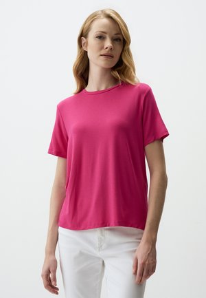 Korte mouwen, ronde hals t-shirt van felroze stof met een zachte textuur, gecombineerd met witte broek. Eenvoudig ontwerp zonder zichtbare patronen of accenten.