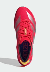 Rode hardloopschoen met een bovenwerk van mesh, zilveren accenten, een gevoerde tong en het "ADIZERO" logo. Heeft een lichtgewicht ontwerp en een rubberen loopzool.