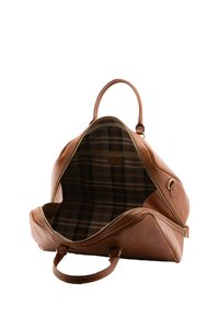 Un sac de voyage en cuir marron avec une forme structurée, doté d'une fermeture éclair et d'une doublure en tissu à carreaux. Deux poignées courtes pour le transport.