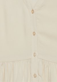 Abito color crema con scollatura a V, bottoni sul davanti e texture arricciata in vita, realizzato in un tessuto liscio.