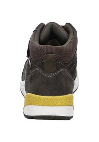 Buty sportowe w stylu mid-top z ciemnobrązową cholewką z zamszu, panelami z siateczki, wyściełanym kołnierzem oraz żółtą gumową podeszwą z teksturowanym wzorem grip.