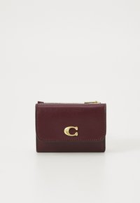 Portefeuille en cuir bordeaux avec un accent logo en m�étal doré, présentant une fermeture à rabat et des détails de couture visibles. Forme rectangulaire compacte.