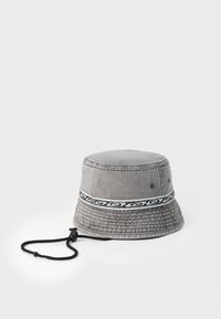 Grå bøttehatt laget av denim med en teksturert overflate. Har et m�ønstret bånd rundt kronen og en svart justerbar snor.