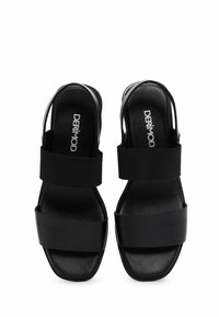 Sandali slingback neri con ampie cinghie elastiche, soletta in pelle liscia e un design elegante con punta quadrata. Costruzione resistente e stile minimalista.