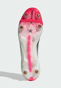 Κάτω όψη ενός ποδοσφαιρικού παπουτσιού με έξι χρυσά καρφιά, κόκκινες λεπτομέρειες και τη λέξη "PREDATOR" κοντά στην περιοχή των δακτύλων.