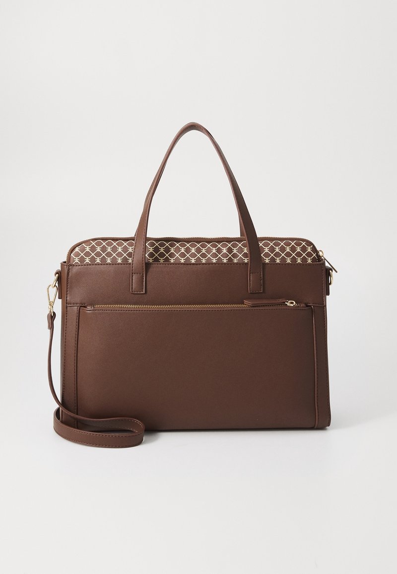 Sac cabas en cuir marron avec double anse, poche zippée devant, bandoulière détachable et bordure en tissu à motifs en haut.