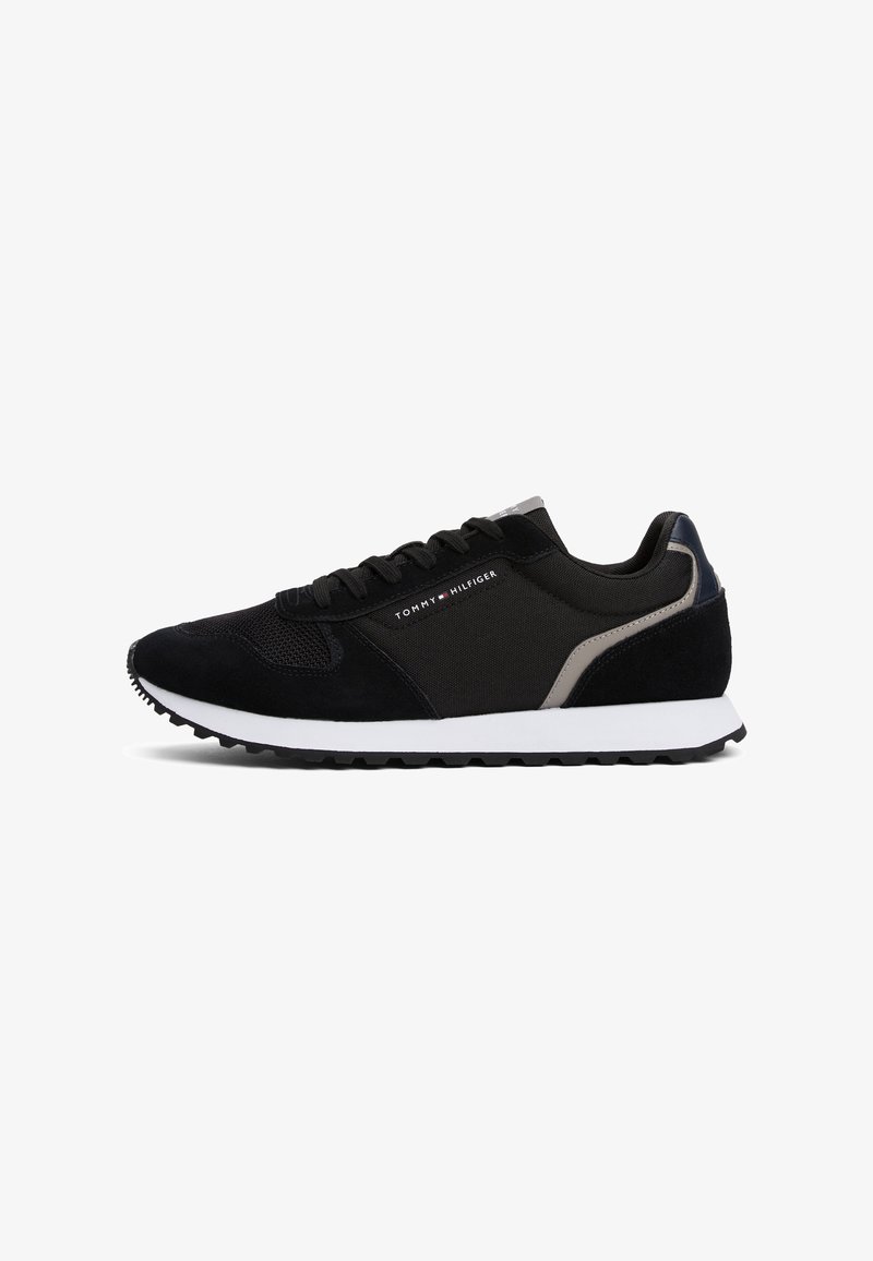 Baskets de course noires avec semelle blanche, dessus en mesh et daim, et logo Tommy Hilfiger sur le côté et le talon.