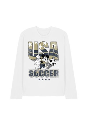 White long-sleeve shirt with "USA Soccer" text, stars, and cartoon character kicking a soccer ball in front of camouflage-patterned letters.