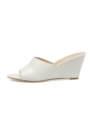 Zueco blanco con cuña y puntera abierta, con parte superior lisa y tacón de altura media, diseñado para uso casual o elegante de mujer.