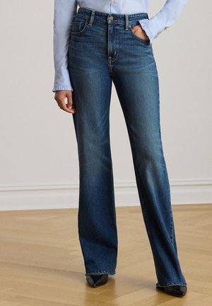 Laiad tumedat sinist teksapükst, millel on kõrge talje, esimesed taskud ja nähtavad õmblused. Sobitatud hele sinine nööbitav särk ja mustad kontsakingad.