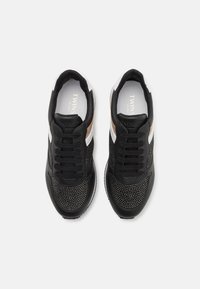 Sneakers neri con tomaia in rete, caratterizzati da borchie argentate, strisce bianche e dorate a contrasto e design a punta rotonda. Lacci neri.