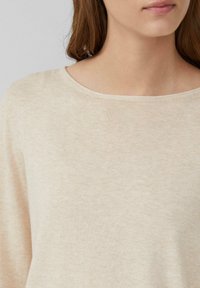 Maglione beige lavorato a maglia con un ampio scollo rotondo e una texture morbida. Presenta un sottile motivo mélange e una vestibilità morbida.