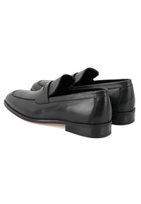 Schwarze Lederloafer mit glatter Textur, ausgestattet mit einer erhöhten Naht und einem flachen Absatz. Das Design umfasst einen rückfreien Schnitt für einfachen Tragekomfort.