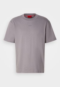 T-shirt gris uni à manches courtes avec un col rond et un logo discret "HUGO" sur la poitrine, présenté sur un fond blanc.