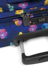 Maleta azul con estampado floral, fabricada con un tejido texturizado, doble cierre, candado de combinación y un mango retráctil negro.