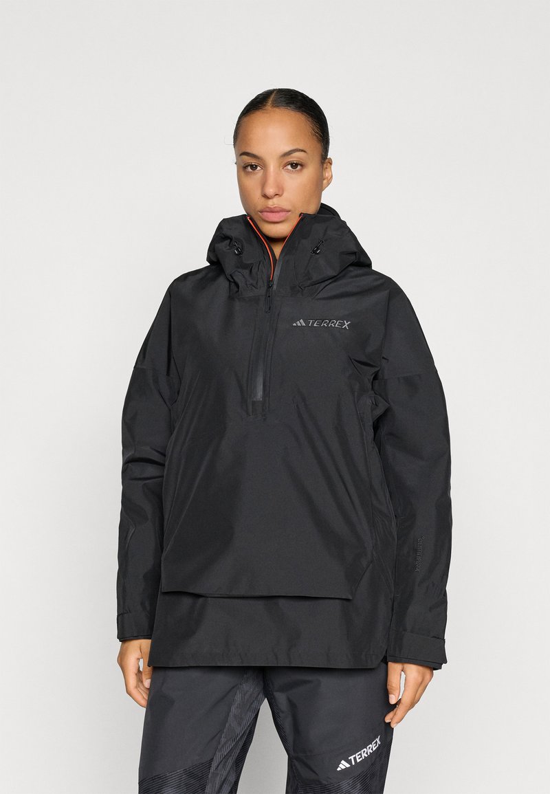 Schwarze wasserdichte Jacke mit Kapuze, halbseitigem Reißverschluss und verstellbaren Funktionen. Logo auf der Brust, leichtes Material und lockere Passform.
