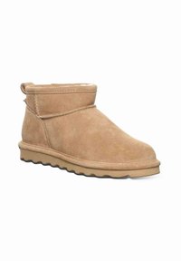 Tan suede ankle boot with rounded toe, stitched cuff, pull tab at heel, and textured rubber sole.