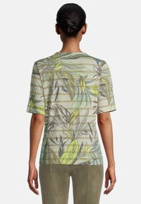 Kortärmad blus i ljusgrön med horisontella ränder och blommönster i gult och grått, med rund halsringning och avslappnad passform.