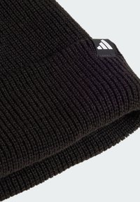 Schwarze Strickmütze mit gerippter Textur und umgeschlagenem Saum, ausgestattet mit einem kleinen schwarz-weißen Logo-Tag.