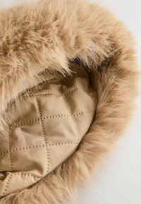 Beige fur-lined hood with a soft, fluffy trim. Interior features a quilted pattern in a matching beige color. Smooth texture throughout.