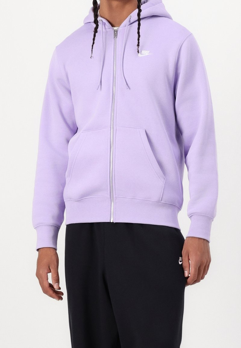 Fialová mikina na zip z měkké látky, s přední kapsou, žebrovanými lemy na rukávech a malým bílým logem Nike na hrudi.