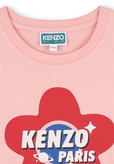 T-shirt en coton rose avec un col rond, ornée d'un grand graphique de fleur rouge, d'un cercle bleu et du texte "KENZO PARIS" en blanc.