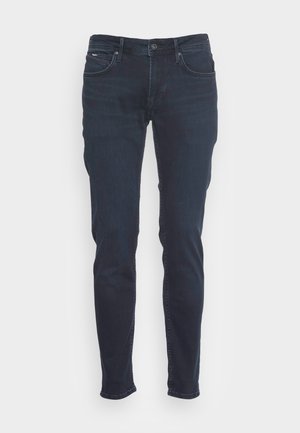 Dunkelblaue Jeans im Slim-Fit-Design. Hergestellt aus Denim, mit einem Knopf- und Reißverschluss, fünf Taschen und dezenten Nähten.