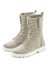 Botines de tobillo beige con cordones, con una parte superior de tela texturizada, suela de goma blanca contrastante y un zipper lateral para un acceso fácil.