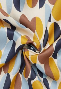 Tessuto intrecciato con un motivo ripetitivo di grandi ovali in blu, marrone, giallo senape e crema, caratterizzato da una superficie liscia e lucida.