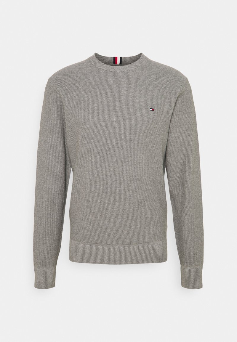 Pull en maille gris clair à manches longues, col rond et petit logo Tommy Hilfiger sur la poitrine gauche.