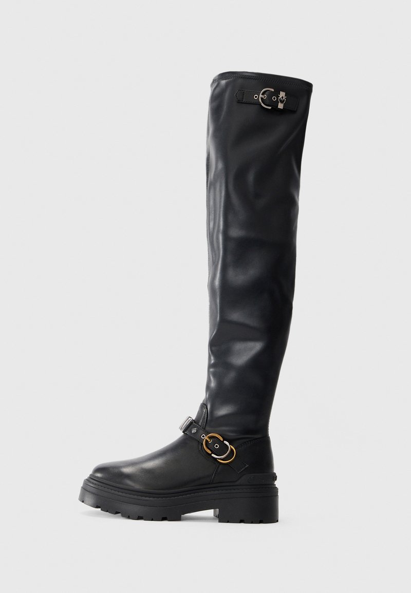 Fekete, térd fölé érő csizmák sima bőrből, vastag talppal, csatos díszítéssel és formás kialakítással.