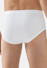 Slip bianchi in cotone con una trama liscia, fascia elastica in vita e un taglio classico, caratterizzati da un design resistente per comfort e supporto.