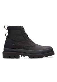 Botas de tobillo negras con un upper de cuero texturizado, cordones entrelazados y una suela de goma gruesa y resistente; cuenta con una tira de agarre en el talón.