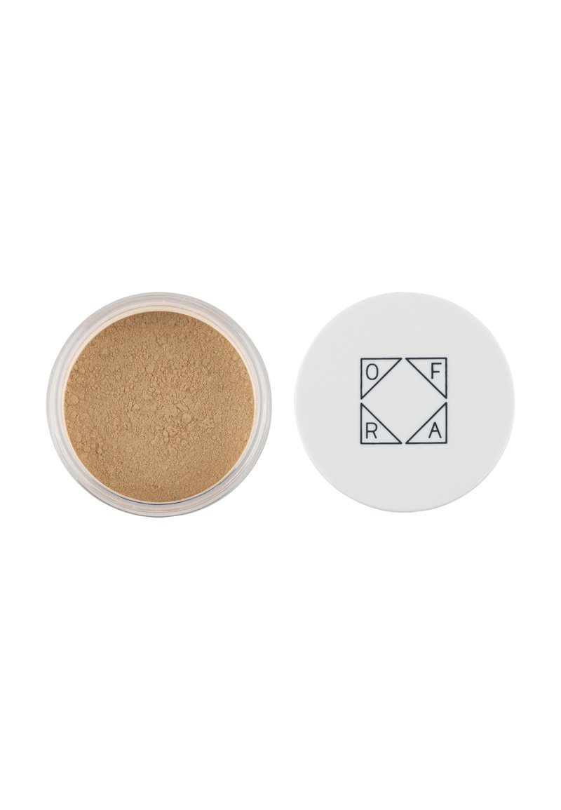 Lös puder smink i en genomskinlig burk med tan-färgat puder inuti; vit lock med OFRA-logotyp i svart geometrisk design.